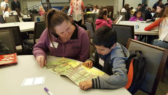 Meadow View student reading to a Sonoma State service-learner.