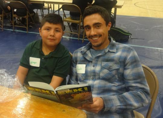 Luther Burbank student, Diego, and their SSU student partner, Paulo, reading a book together.