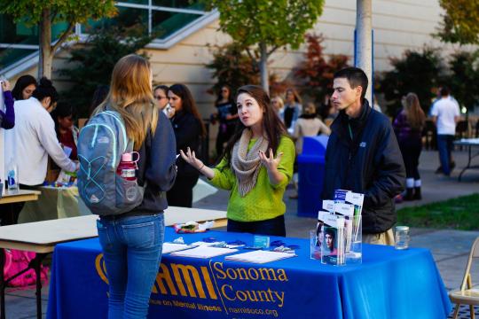 The NAMI representatives and Maddie discussing their organization during the Mental Health Promotion Fair.