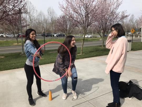 RCP and SSU students attempting to pass along a hula hoop with only their arms.