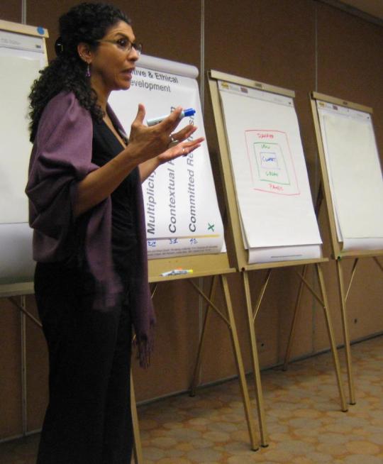 person speaking in front of poster presentations