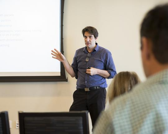 Dr. Qualls presenting in front of a projector screen