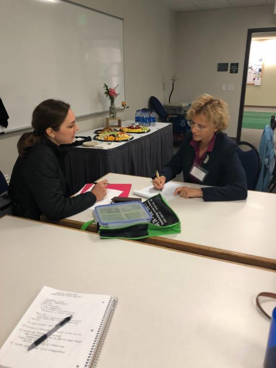 two faculty members talking at a table